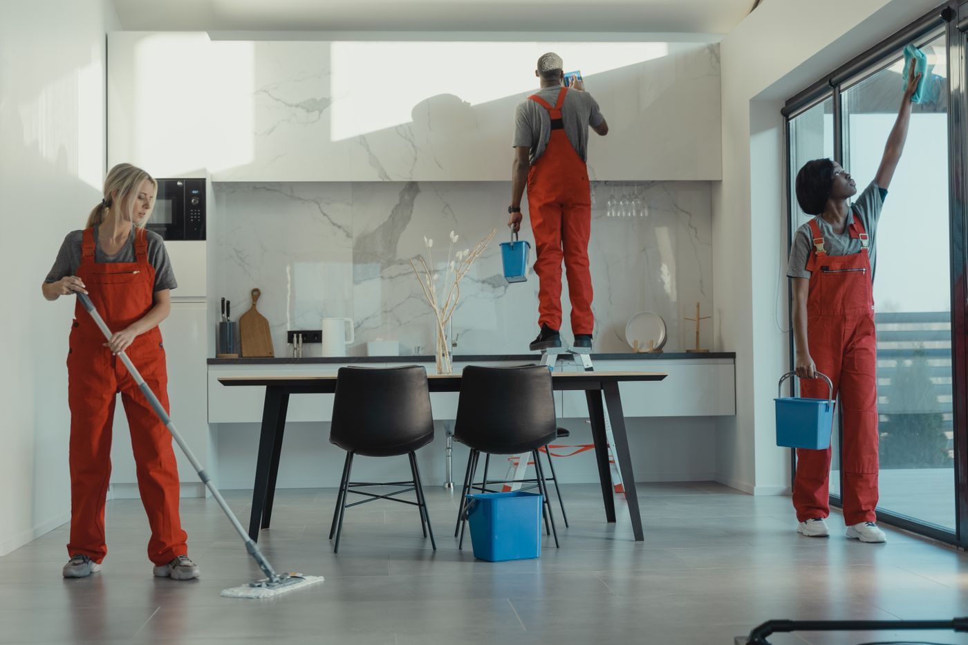 Landmark cleaning crew mopping and wiping a modern office kitchen